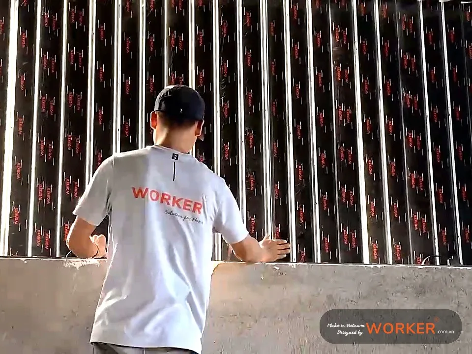 Thợ lắp cửa chớp lam đứng trong nhà trần gỗ