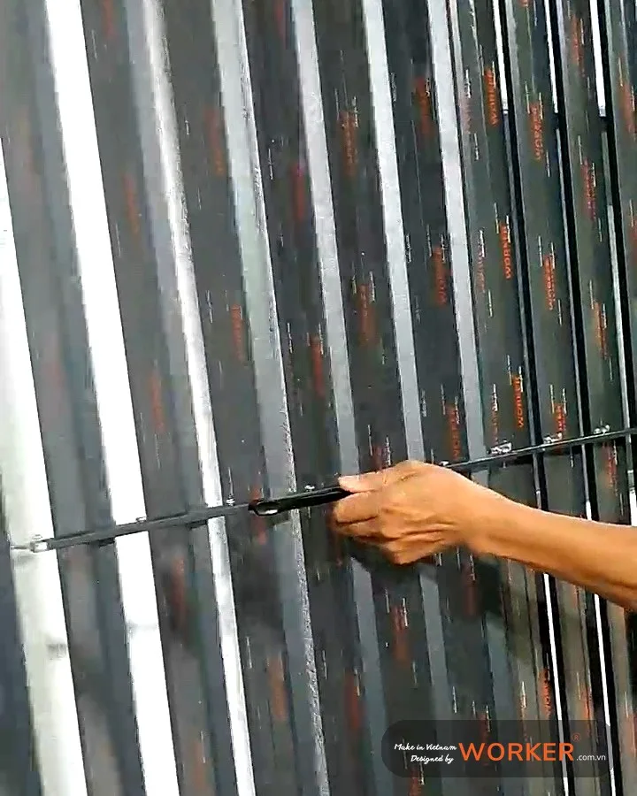 Tay thợ kéo thanh điều khiển lật lá trên tấm cửa chớp lật còn màng bảo vệ